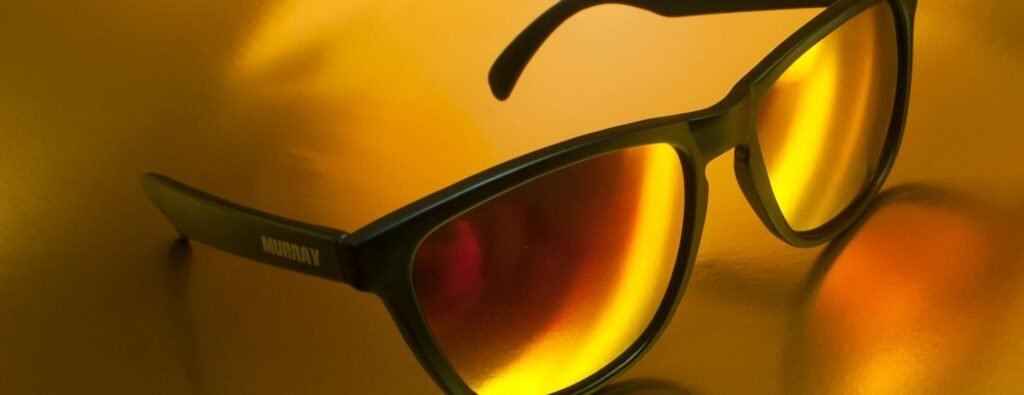 Lunettes de soleil sur fond dorée.