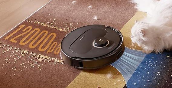 Un aspirateur robot Dreame de 12 000 Pa aspirant des débris et des poils près d'un chat blanc sur un tapis coloré