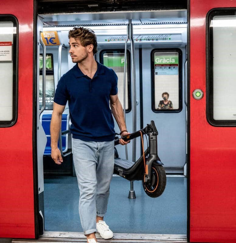 Trottinette électrique pliée et transportée dans le métro ou les transports en commun