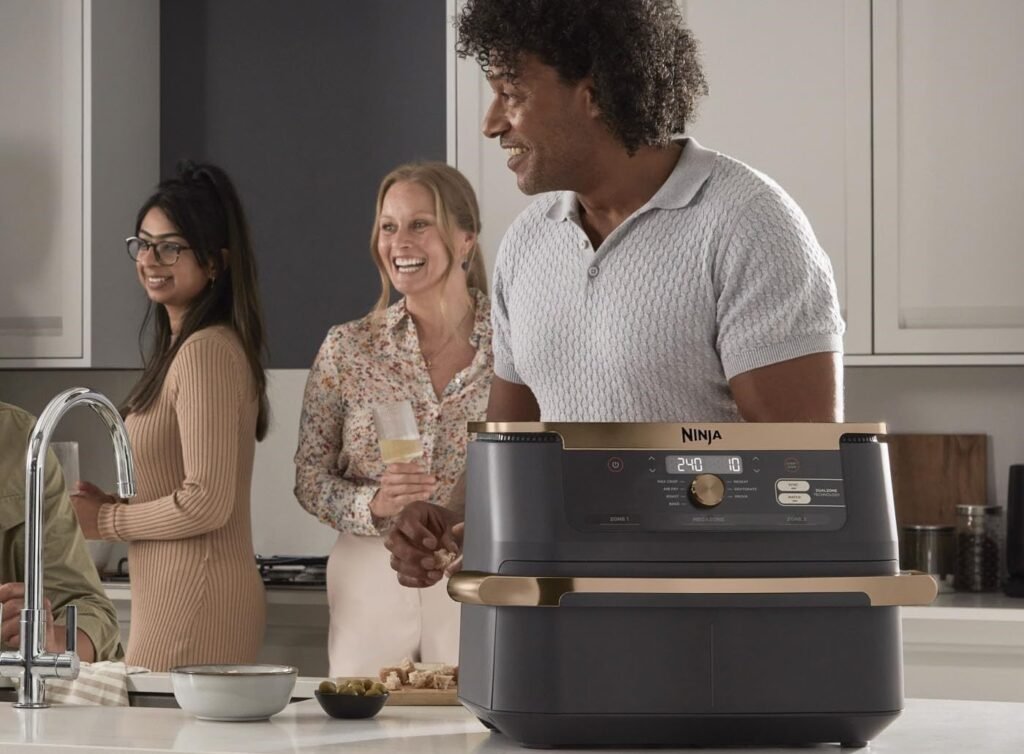Groupe d’amis souriants près du Ninja airfryer Dual Zone dans une cuisine élégante