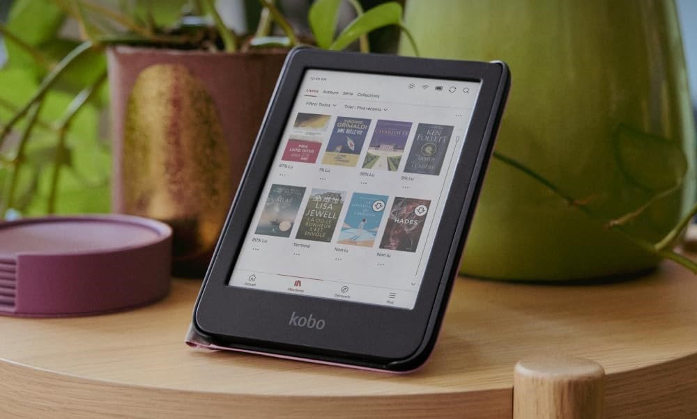 Liseuse Kobo e-reader : cadeaux tech couple, écran bibliothèque livres sur table bois avec plantes vertes en arrière-plan.